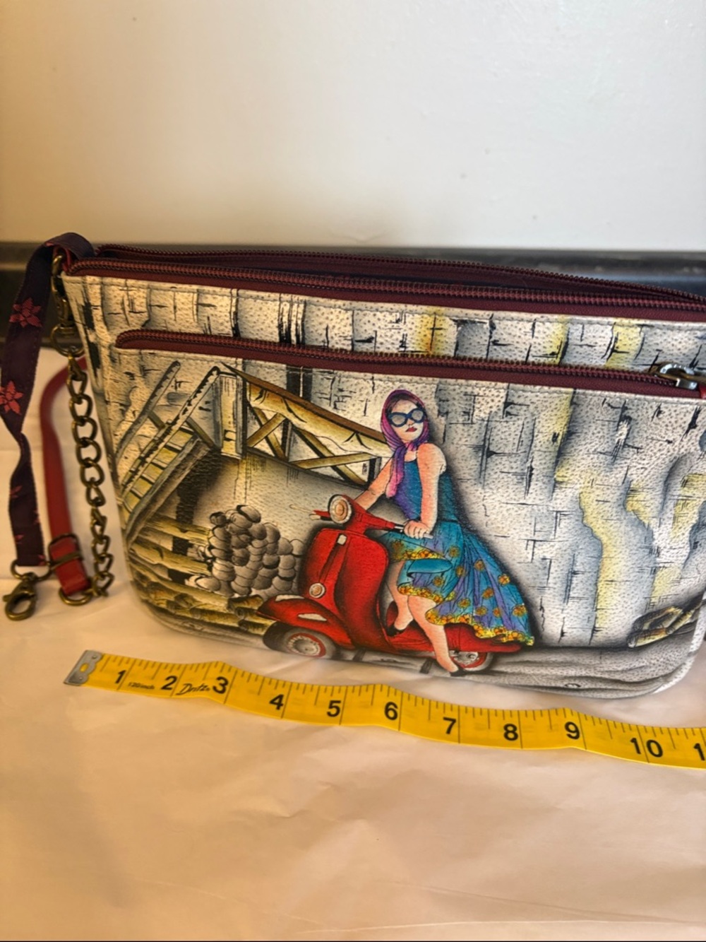 Anuschka Painted Crossbody Clutch in Red, Blue and Purple women on scooter